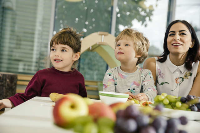 Children and teacher sitting at table with fruit in kindergarten Royalty free image Children and teacher sitting at table with fruit in kindergarten
Royalty free image