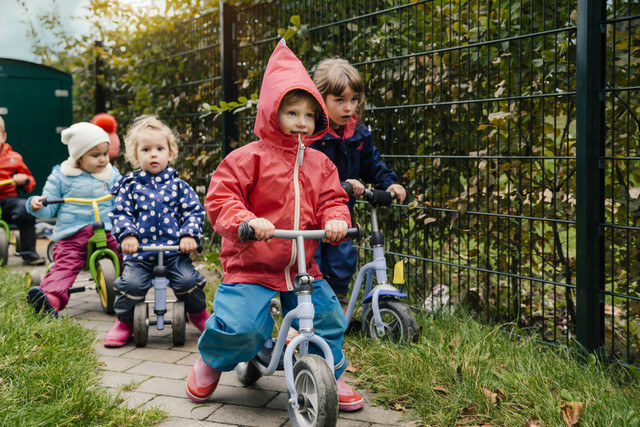Children using scooters in garden of a kindergarten Royalty free image Children using scooters in garden of a kindergarten
Royalty free image