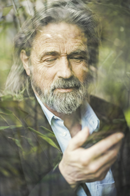 Stockfoto, lizenzfrei, Leitender Geschäftsmann steht am Fenster und benutzt ein Smartphone
