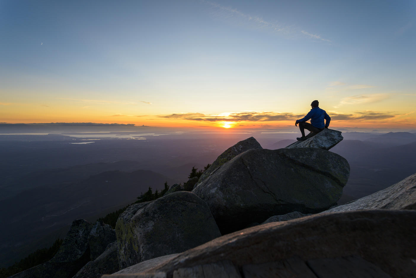 Mann sitzt auf einem Felsen gegen den Himmel im Mount Pilchuck State Park bei Sonnenuntergang Lizenzfreies Stockfoto Mann sitzt auf einem Felsen gegen den Himmel im Mount Pilchuck State Park bei Sonnenuntergang
Lizenzfreies Stockfoto