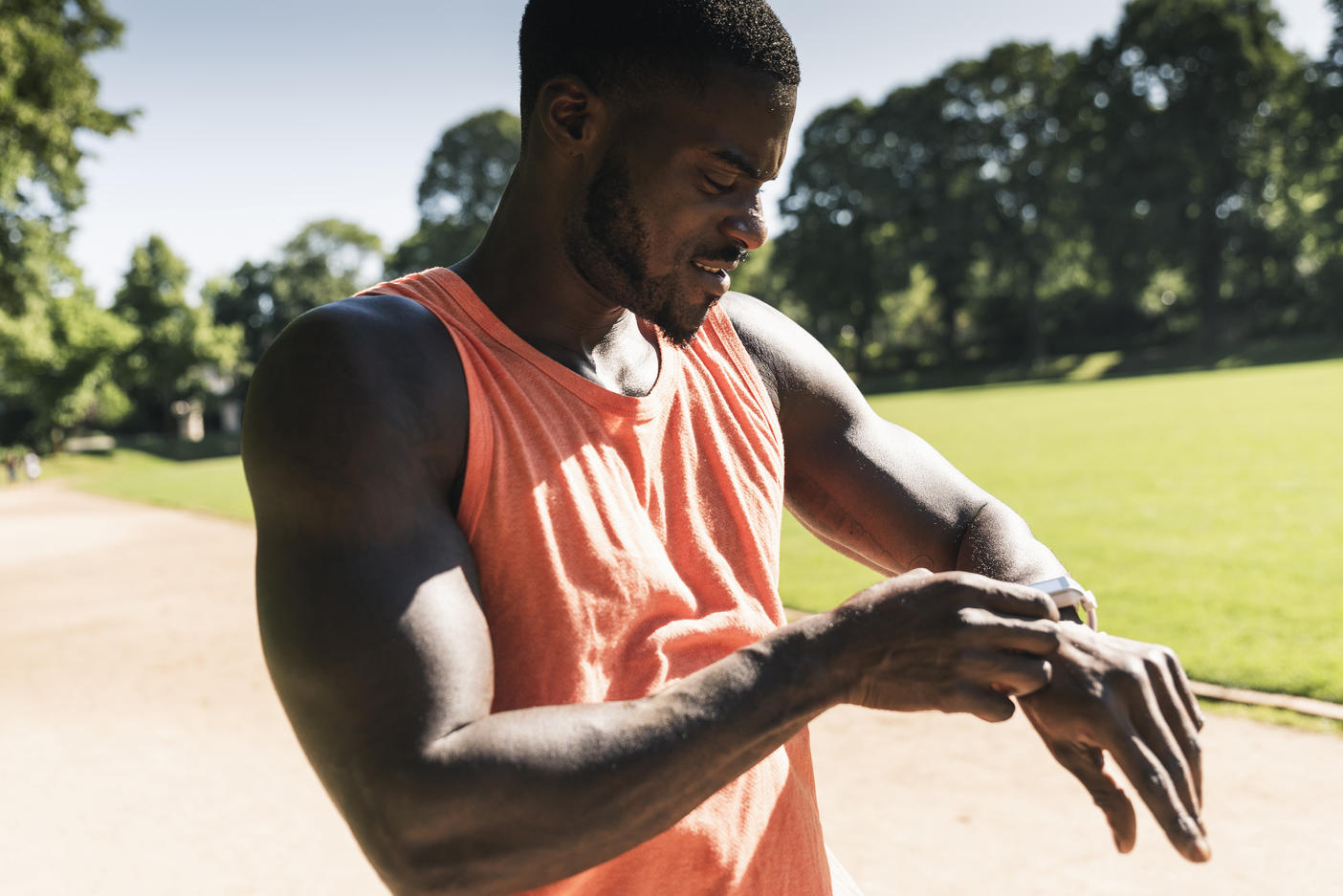 Young athlete in training on sports field taking the time on his smartwatch
Royalty free image