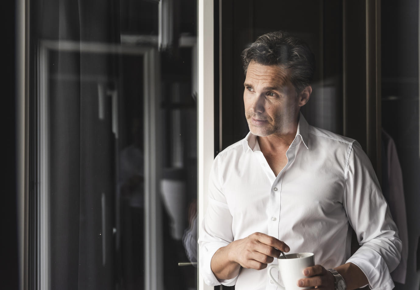 Businessman with cup of coffee looking out of window at home
Royalty free image