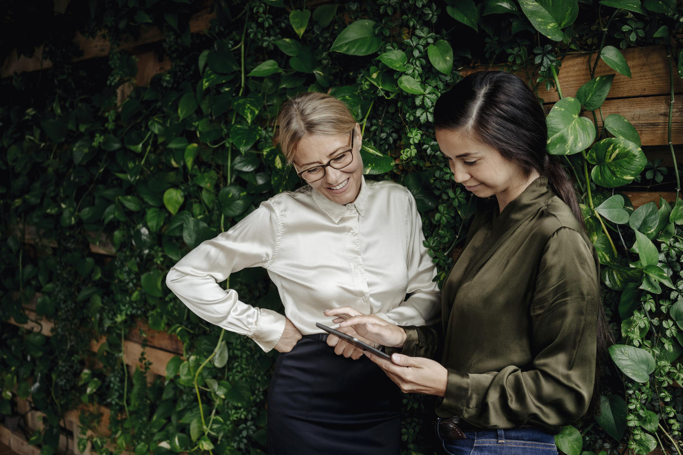 Two businesswomen in green office looking at tablet
Royalty free image