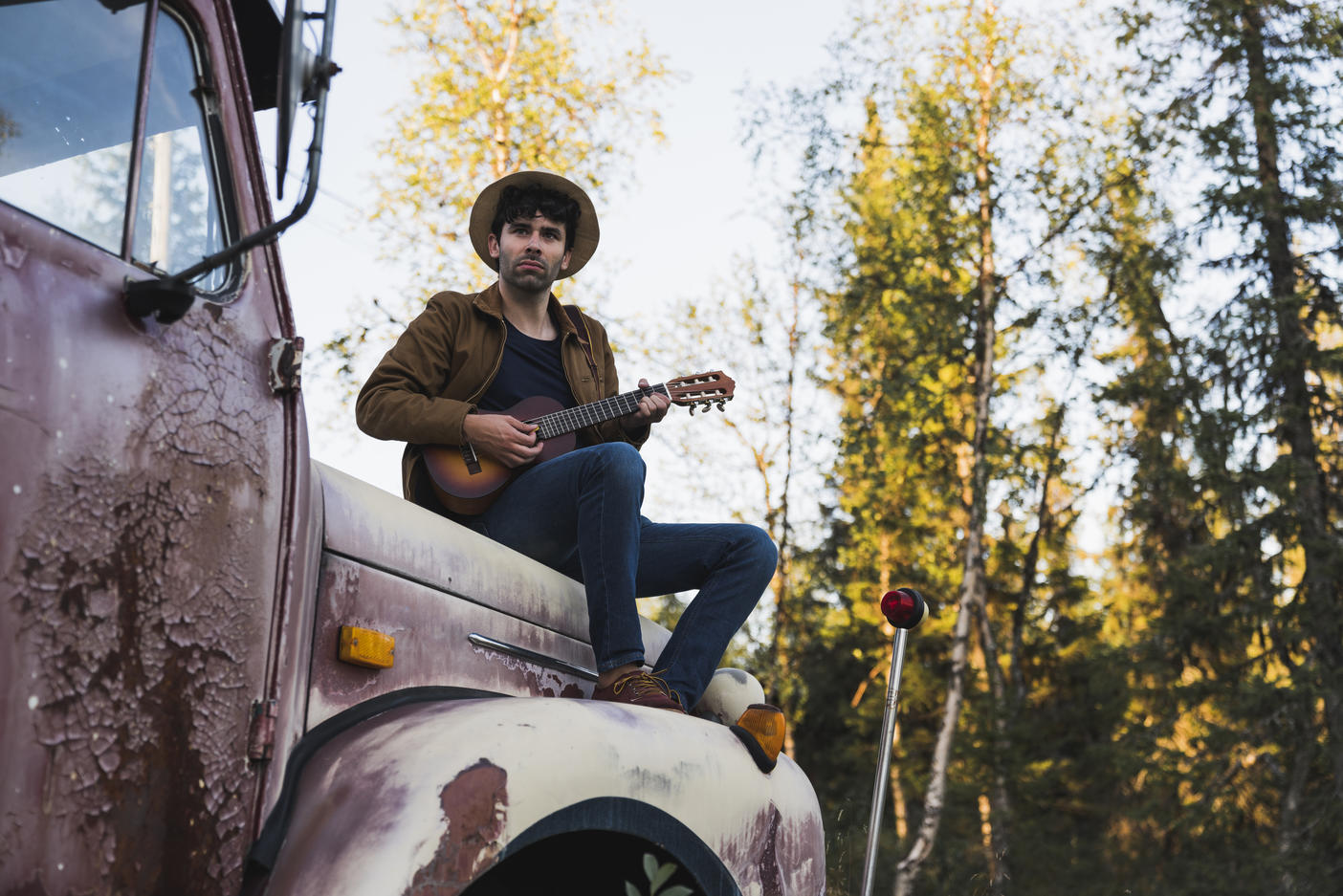 Young man sitting on a broken truck, playing the ukulele Royalty free image Young man sitting on a broken truck, playing the ukuleleRoyalty free image