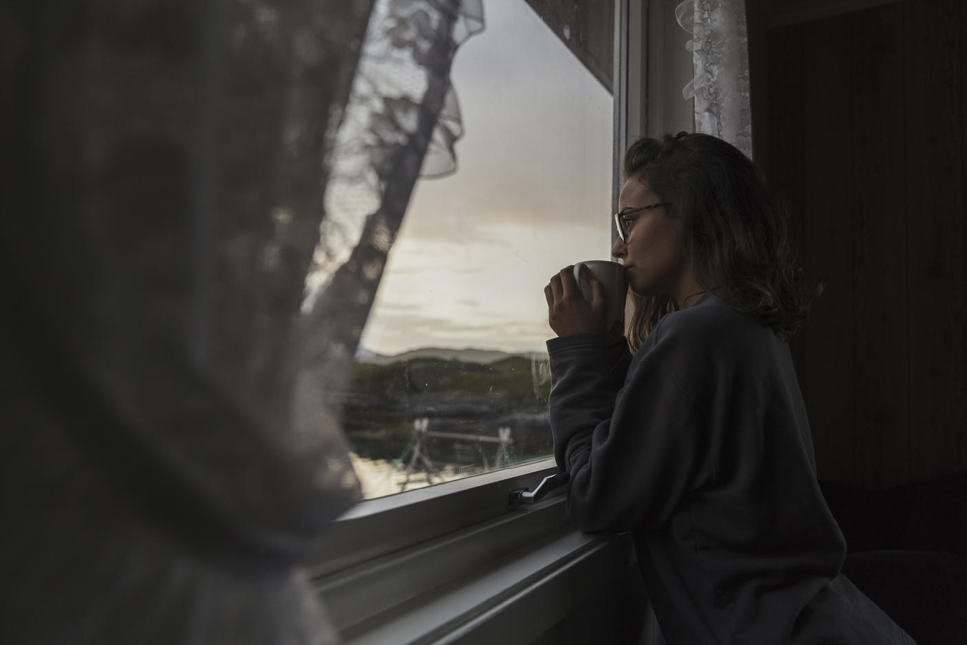 Young woman looking out of window, drinking tea Royalty free image Young woman looking out of window, drinking teaRoyalty free image