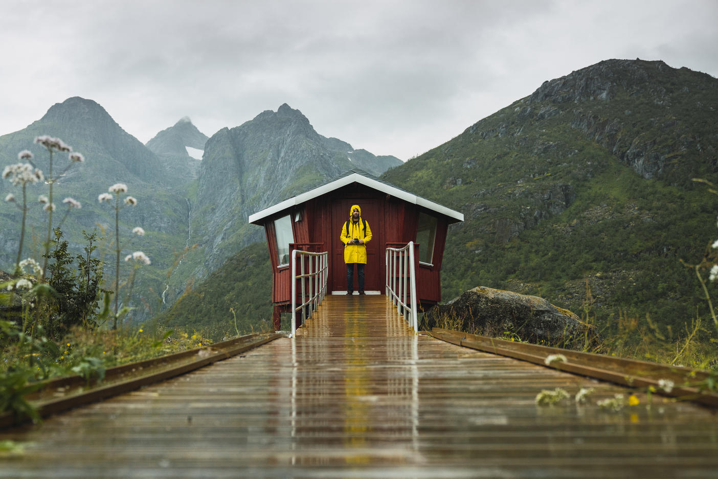 Man in yellow rain jacket waiting at red wood shack, Lapland, Norway Royalty free image Man in yellow rain jacket waiting at red wood shack, Lapland, NorwayRoyalty free image