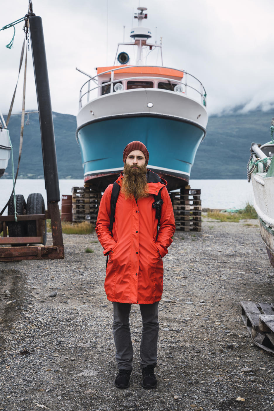 Young man standing in front of a ship, wearing rain clothes, Lapland, Norway Royalty free image Young man standing in front of a ship, wearing rain clothes, Lapland, NorwayRoyalty free image