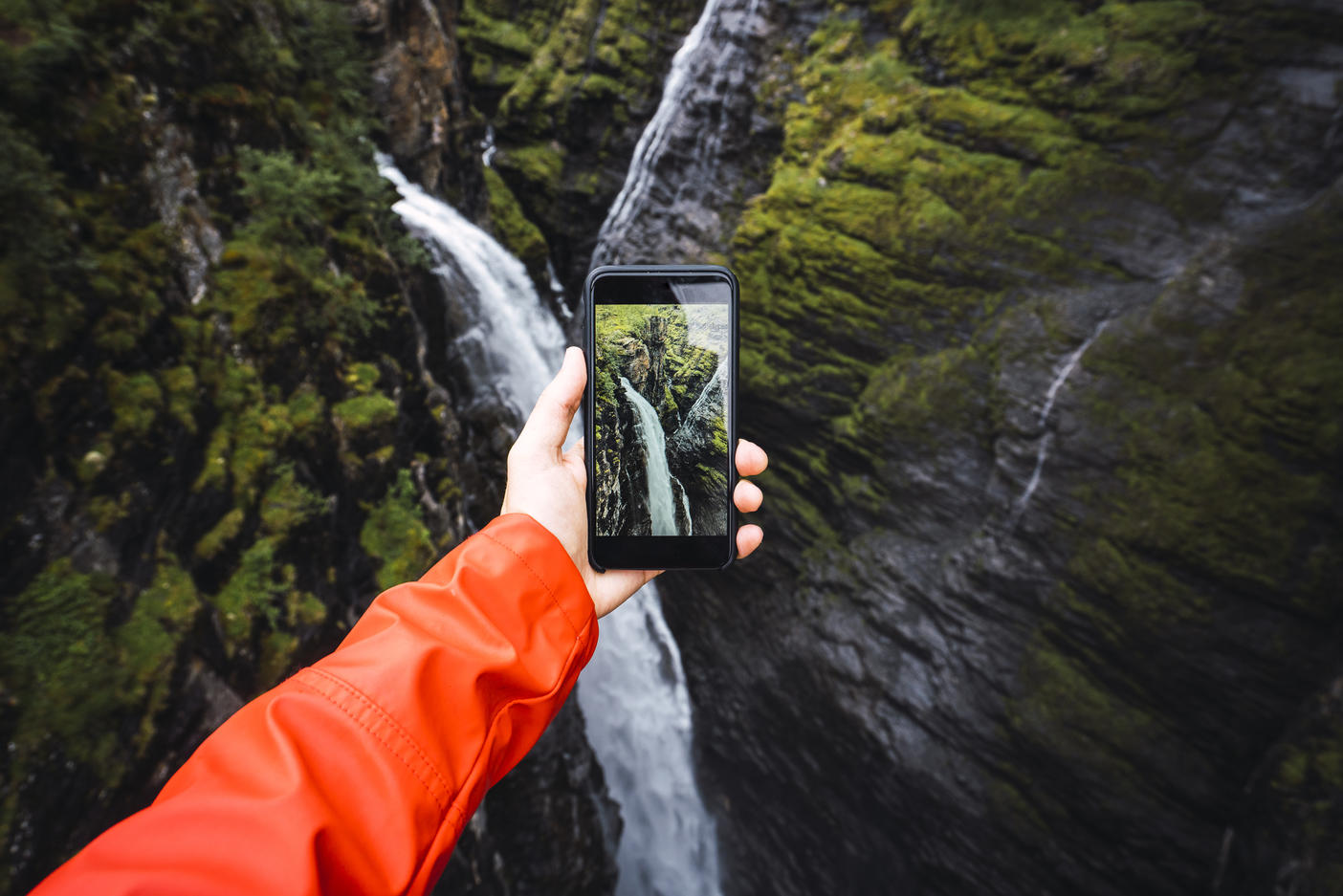 Person taking smartphone picture of a waterfall, Lapland, Norway Royalty free image Person taking smartphone picture of a waterfall, Lapland, NorwayRoyalty free image