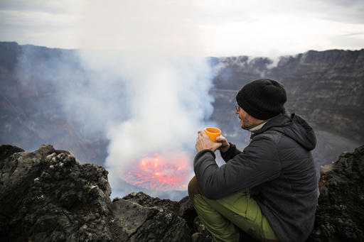 Africa, Democratic Republic of Congo, Virunga National Park, Man sittiing over Nyiragongo volcano crater
Royalty free image