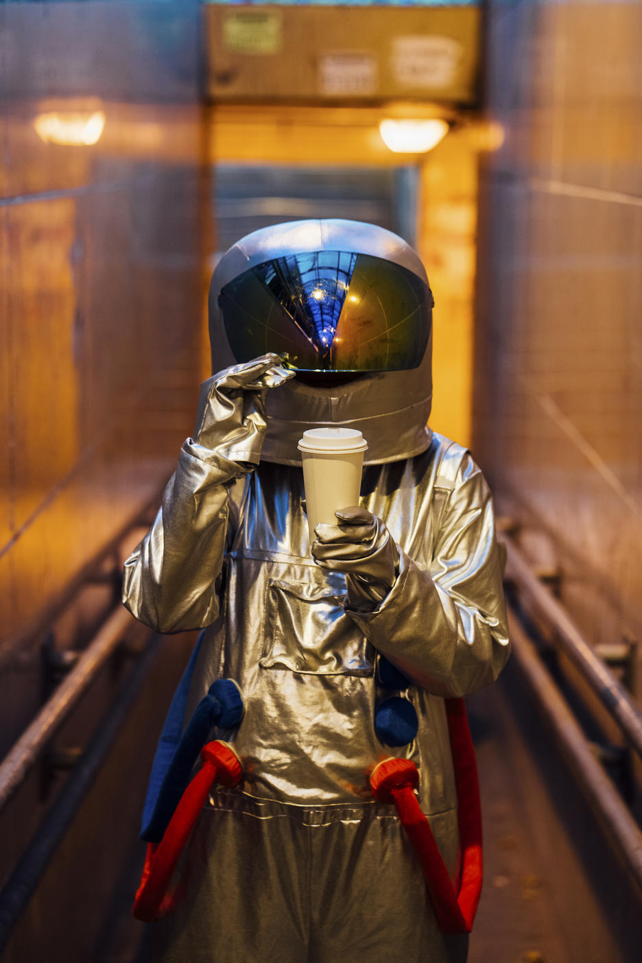 Spaceman in the city at night with takeaway coffee in narrow passageway
Royalty free image