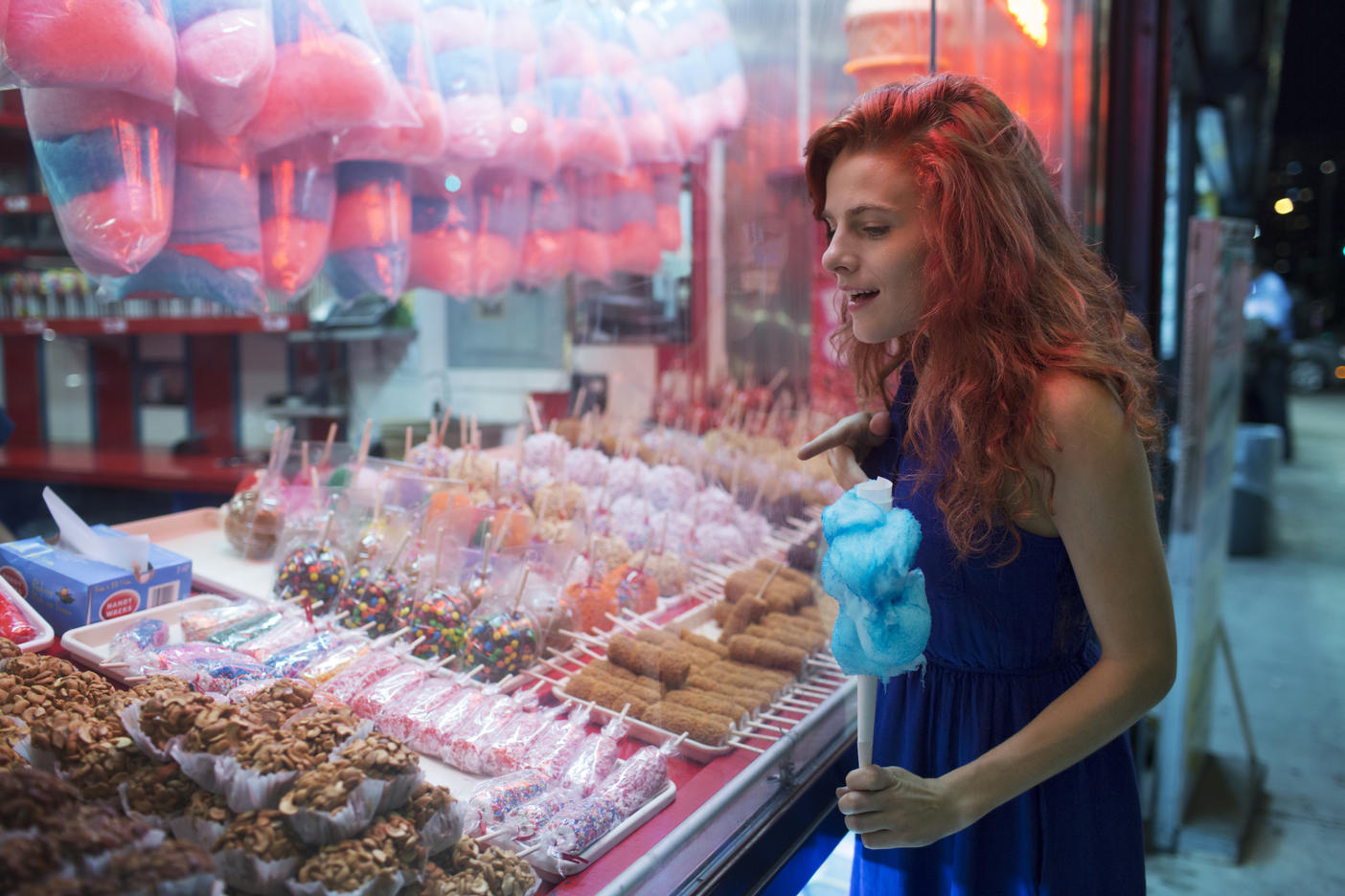 Curious woman looking at deserts in stall at amusement park
Royalty free image