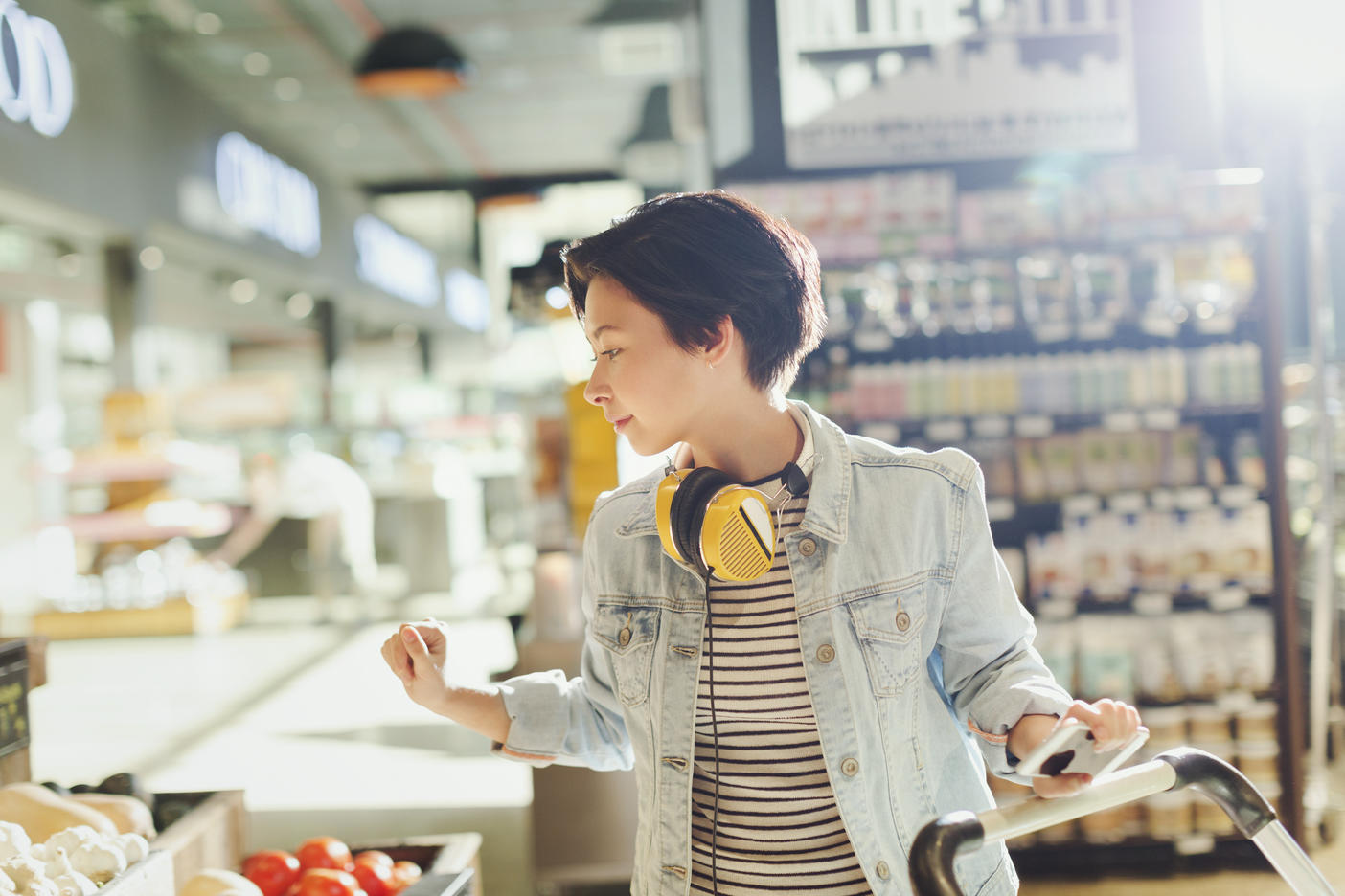 Young woman with headphones browsing, grocery shopping in market
Royalty free image