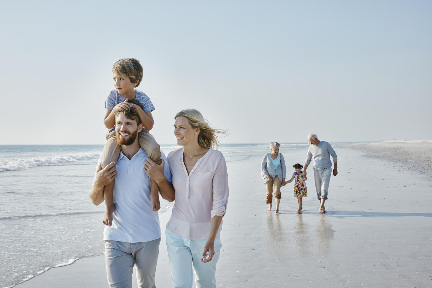 Happy extended family strolling on the beachRoyalty free image