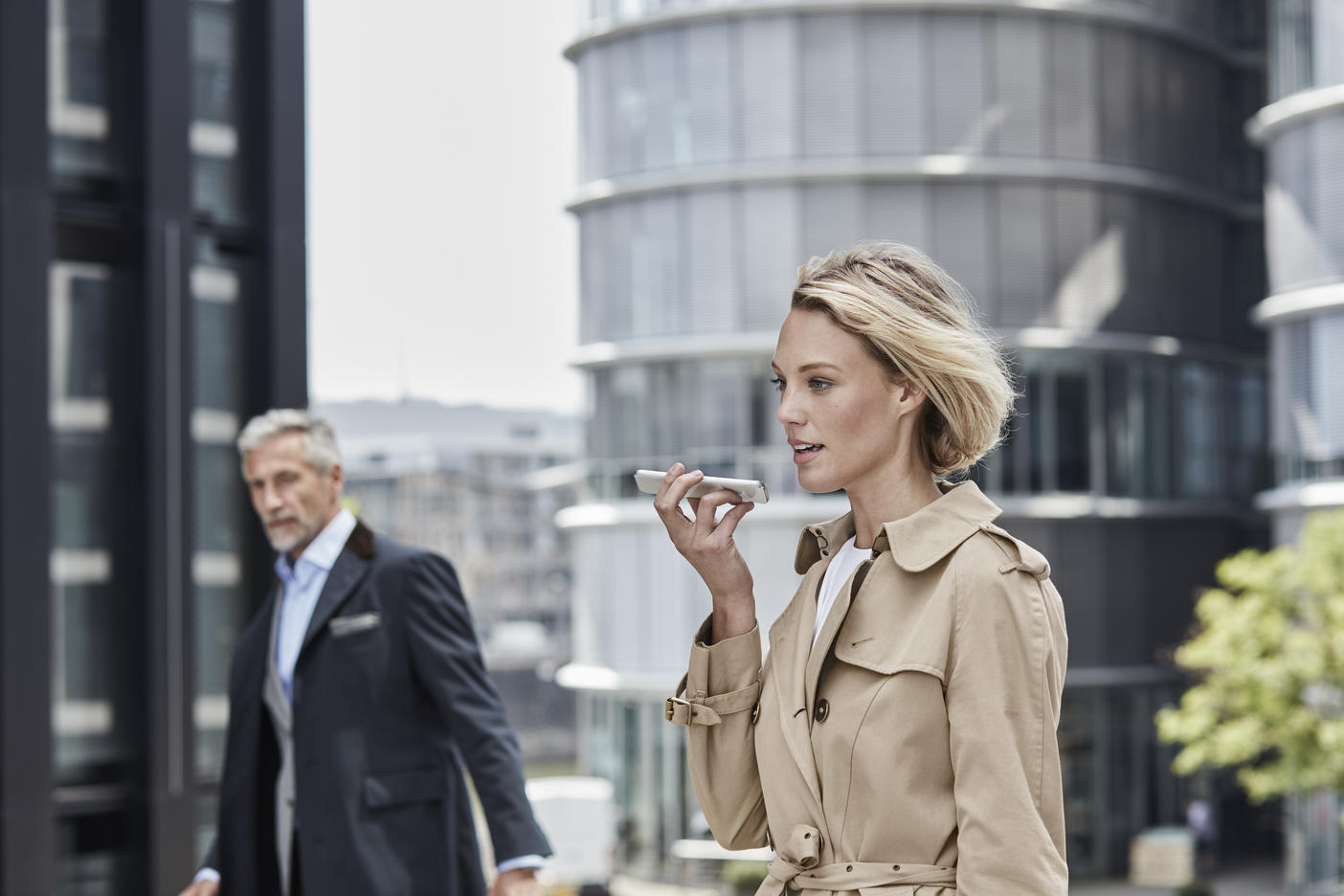 Germany, Duesseldorf, portrait of blond businesswoman wearing beige trenchcoat talking on mobile phoneRoyalty free image