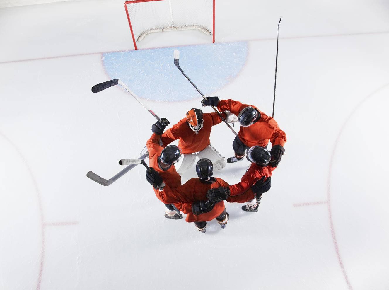 Overhead view hockey team in red uniforms huddling on ice
Royalty free image