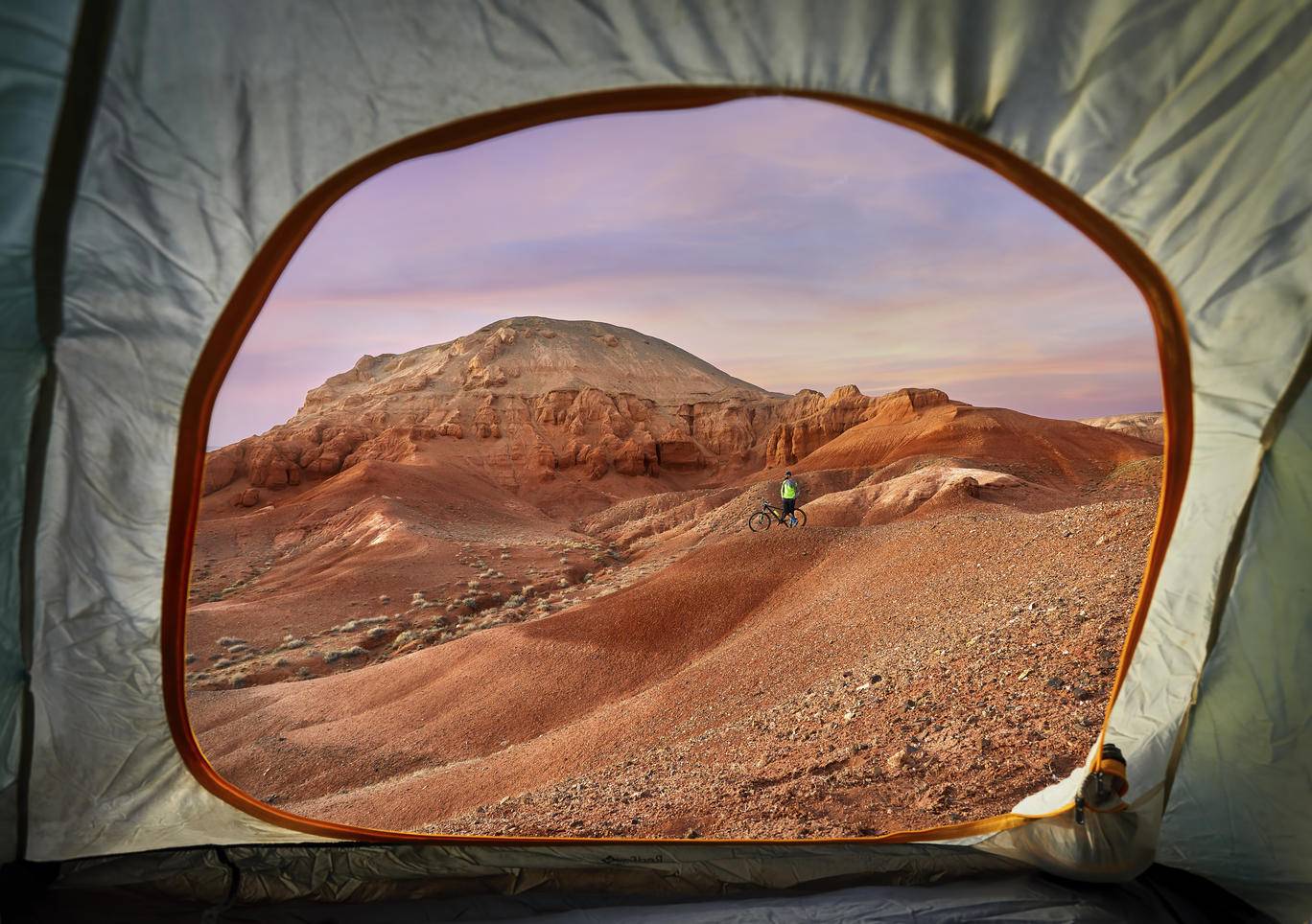 Mid distance view of hiker at desert seen through tent during sunset
Royalty free image