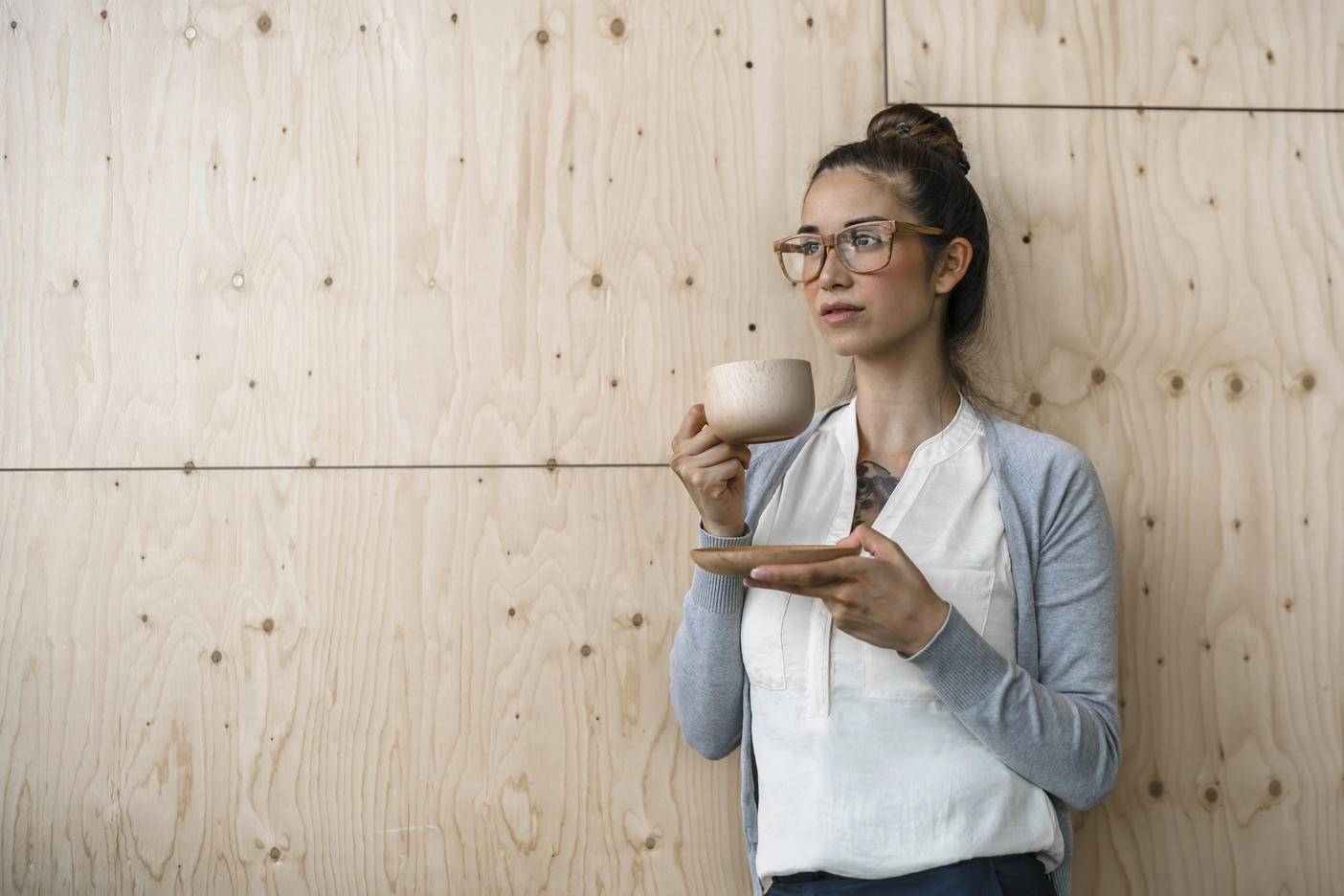 Young woman working in creative office, taking a break, drinking coffee from wooden cup
Royalty free image