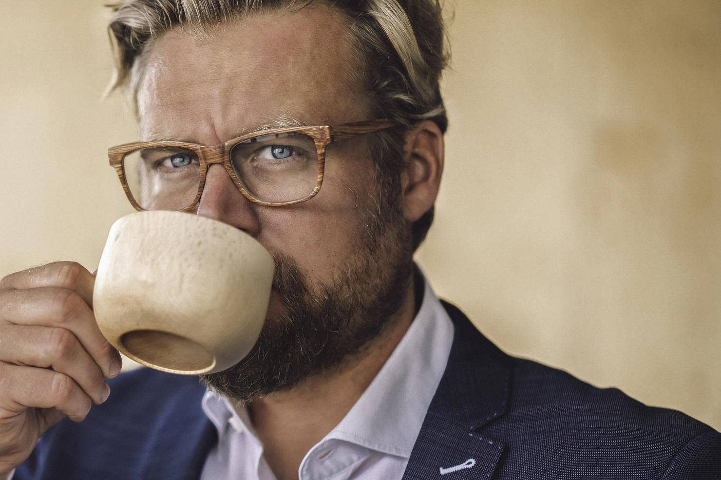 Businessman standing in office, drinking coffee from a wooden cup
Royalty free image