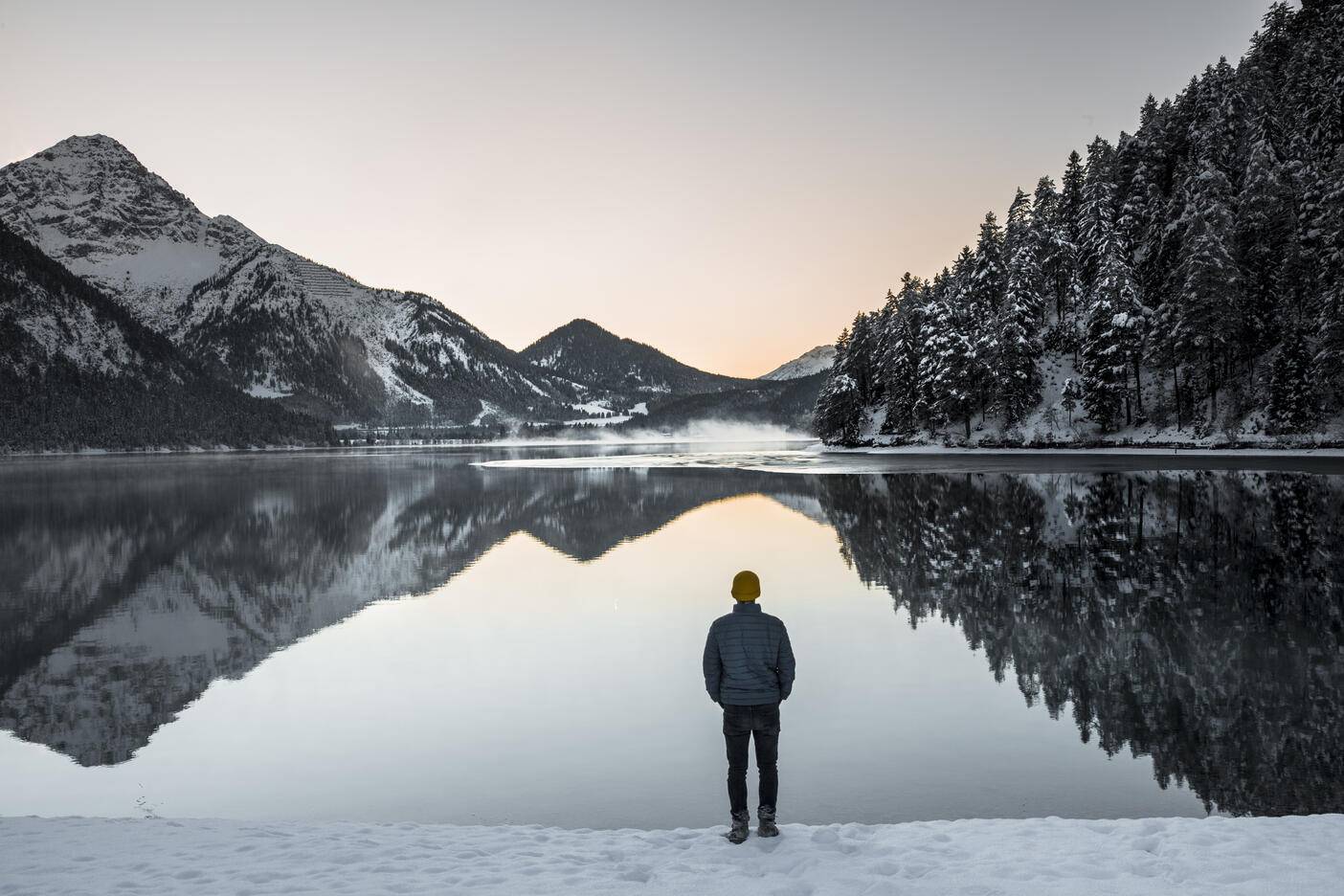 Rear view of man standing at lakeshore against sky during winter
Royalty free image