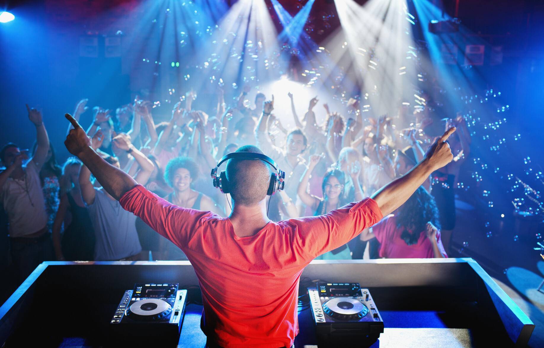 DJ with arms outstretched overlooking dance floor Royalty free image DJ with arms outstretched overlooking dance floor
Royalty free image