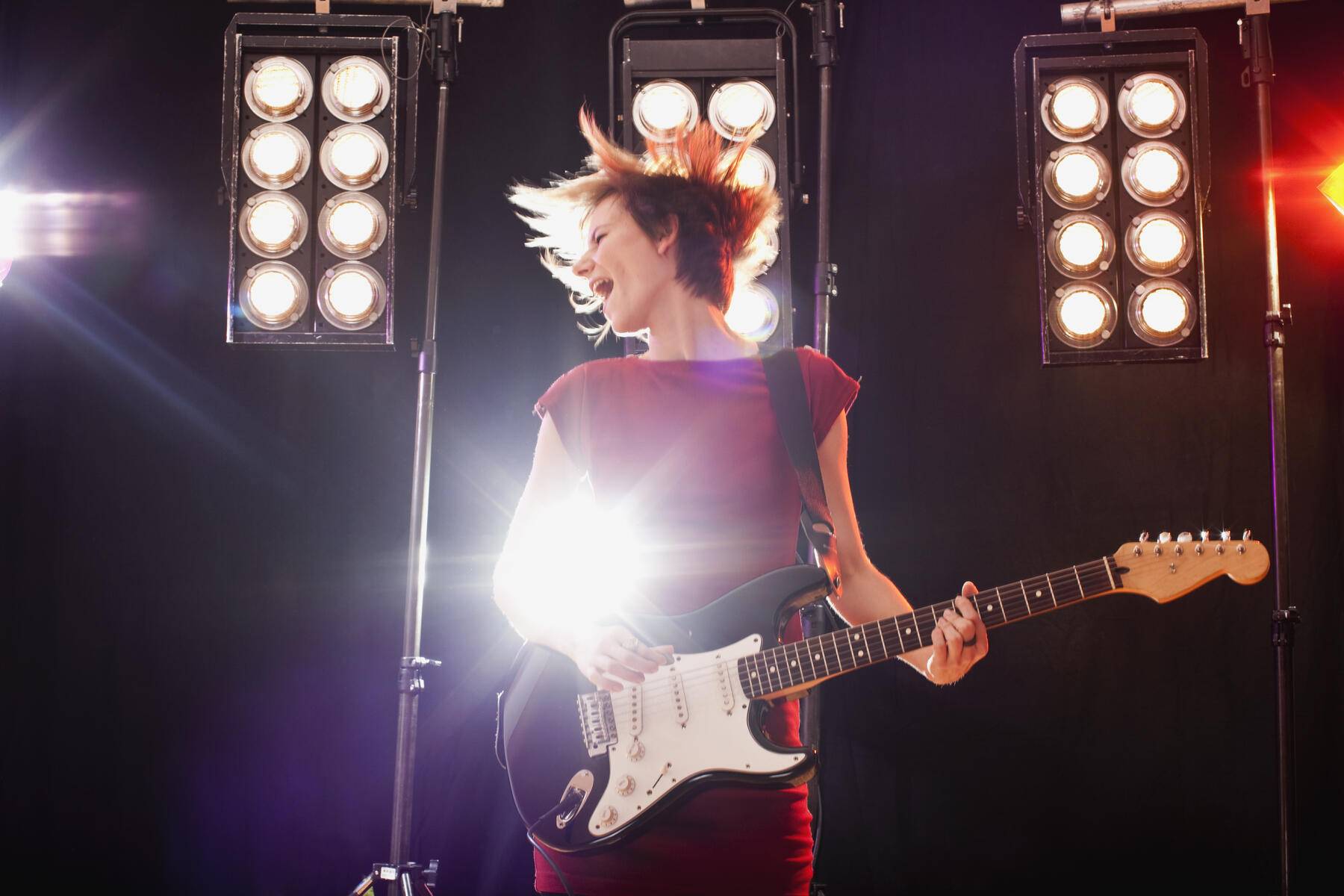 A woman playing electric guitar performing on stage Royalty free image A woman playing electric guitar performing on stage
Royalty free image