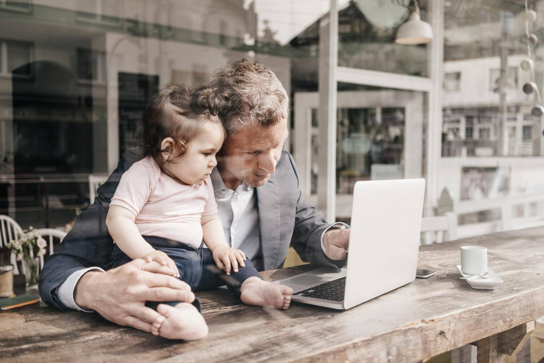 Businessman with little daughter working on laptop in cafe
Royalty free image