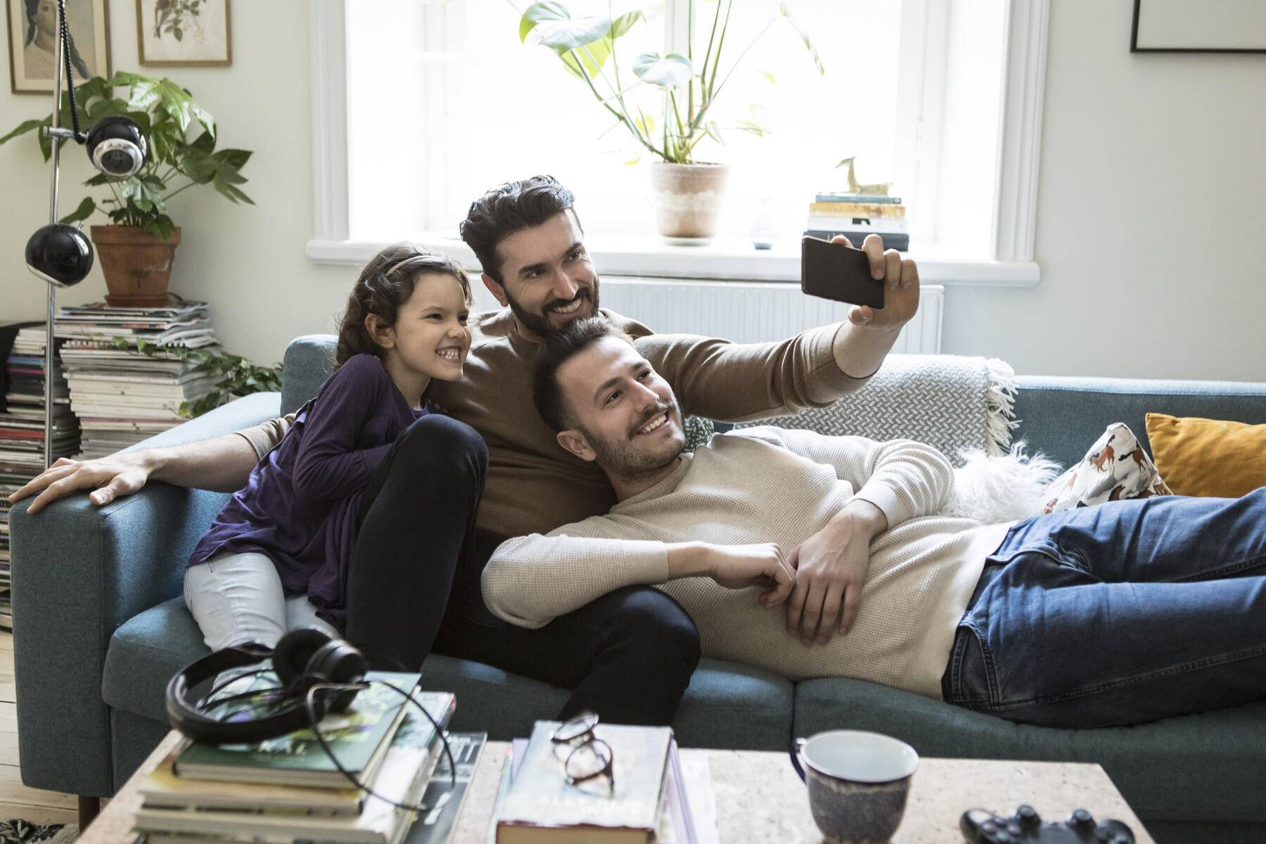 Fathers taking selfie with daughter through mobile phone on sofa at home
Royalty free image