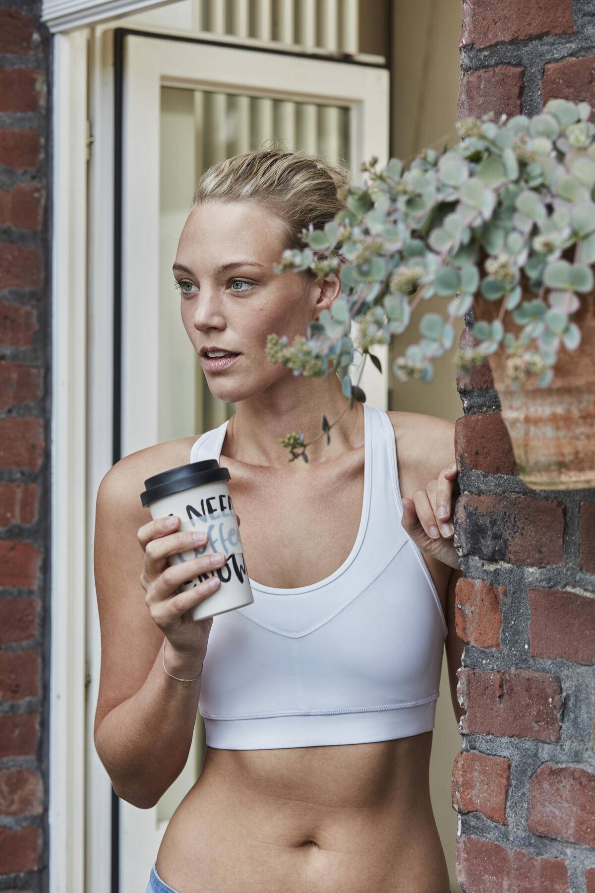 Sporty young woman with takeaway drink at house entrance
Royalty free image