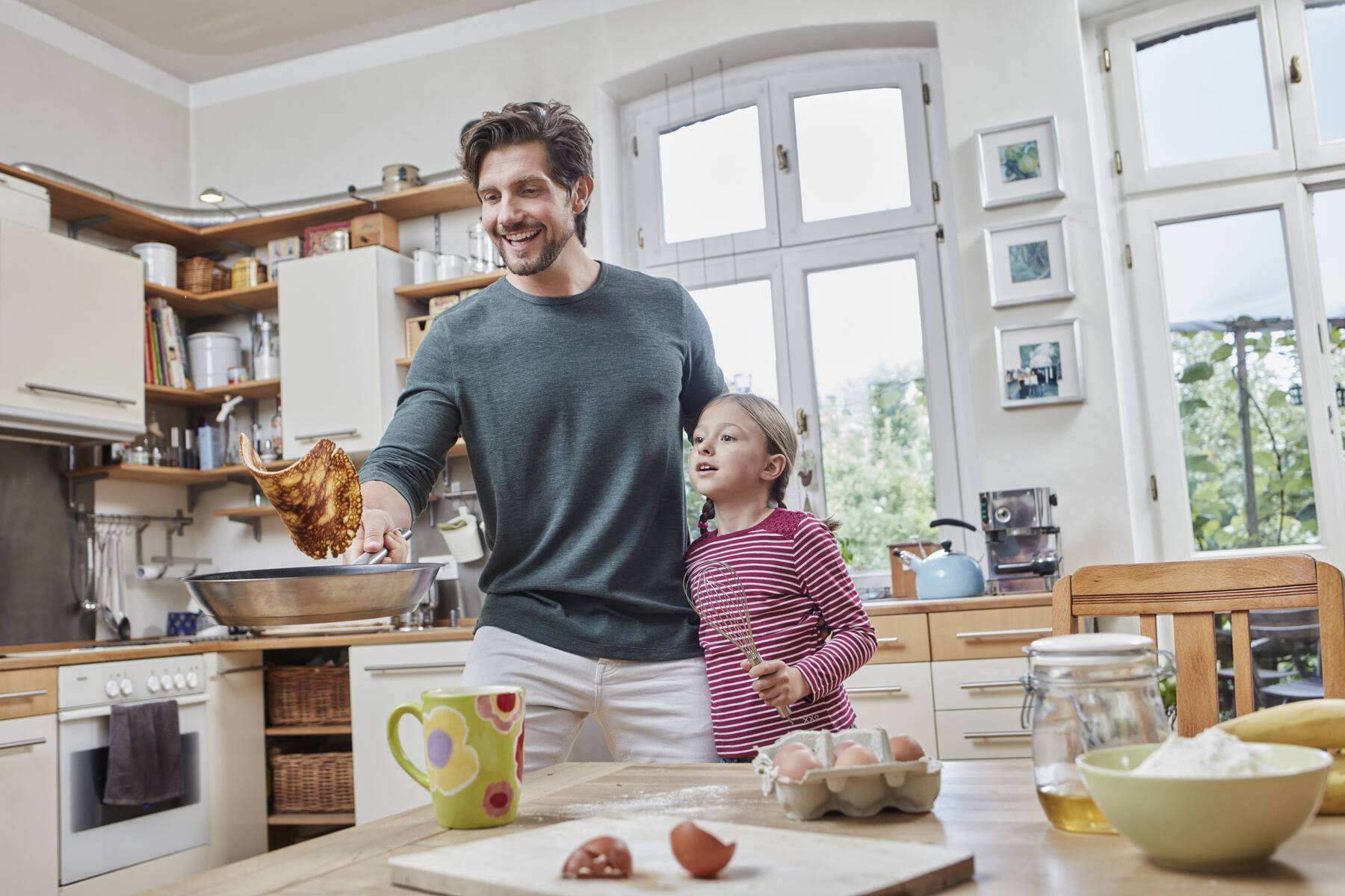 Happy father and daughter baking pancakes in kitchen at home together
Royalty free image