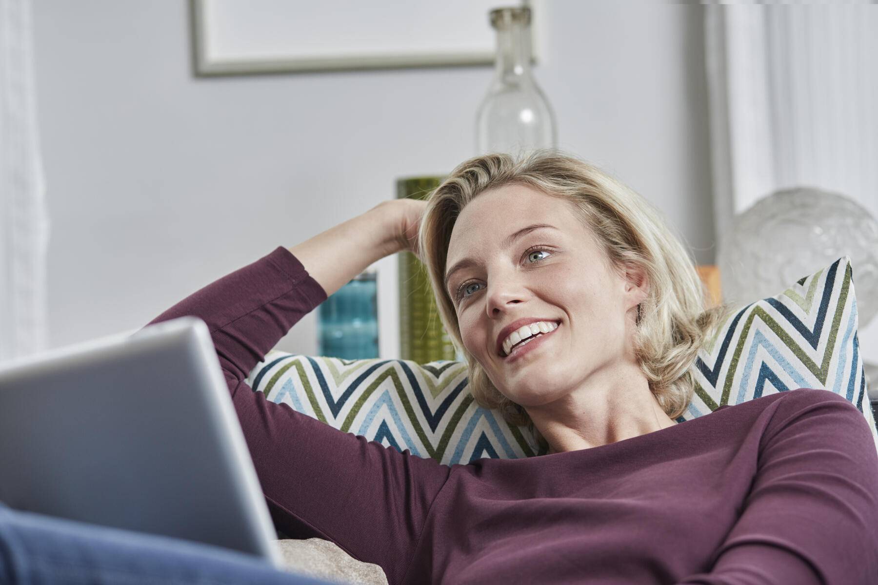 Smiling young woman with tablet lying on couch at home
Royalty free image
