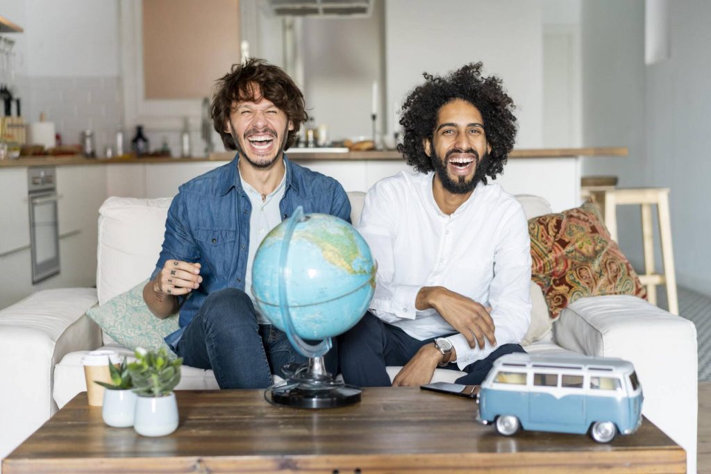 Friends sitting on couch, planning road trip - AFVF02539