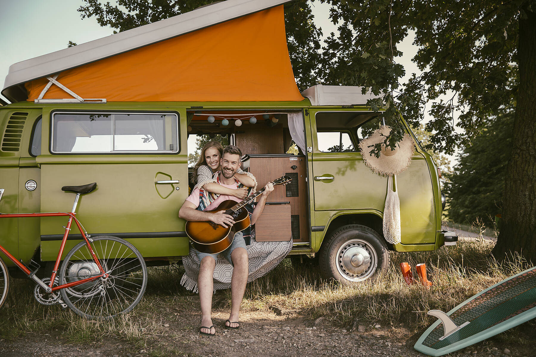 stock image, royalty-free, Smiling woman hugging man in van playing guitar