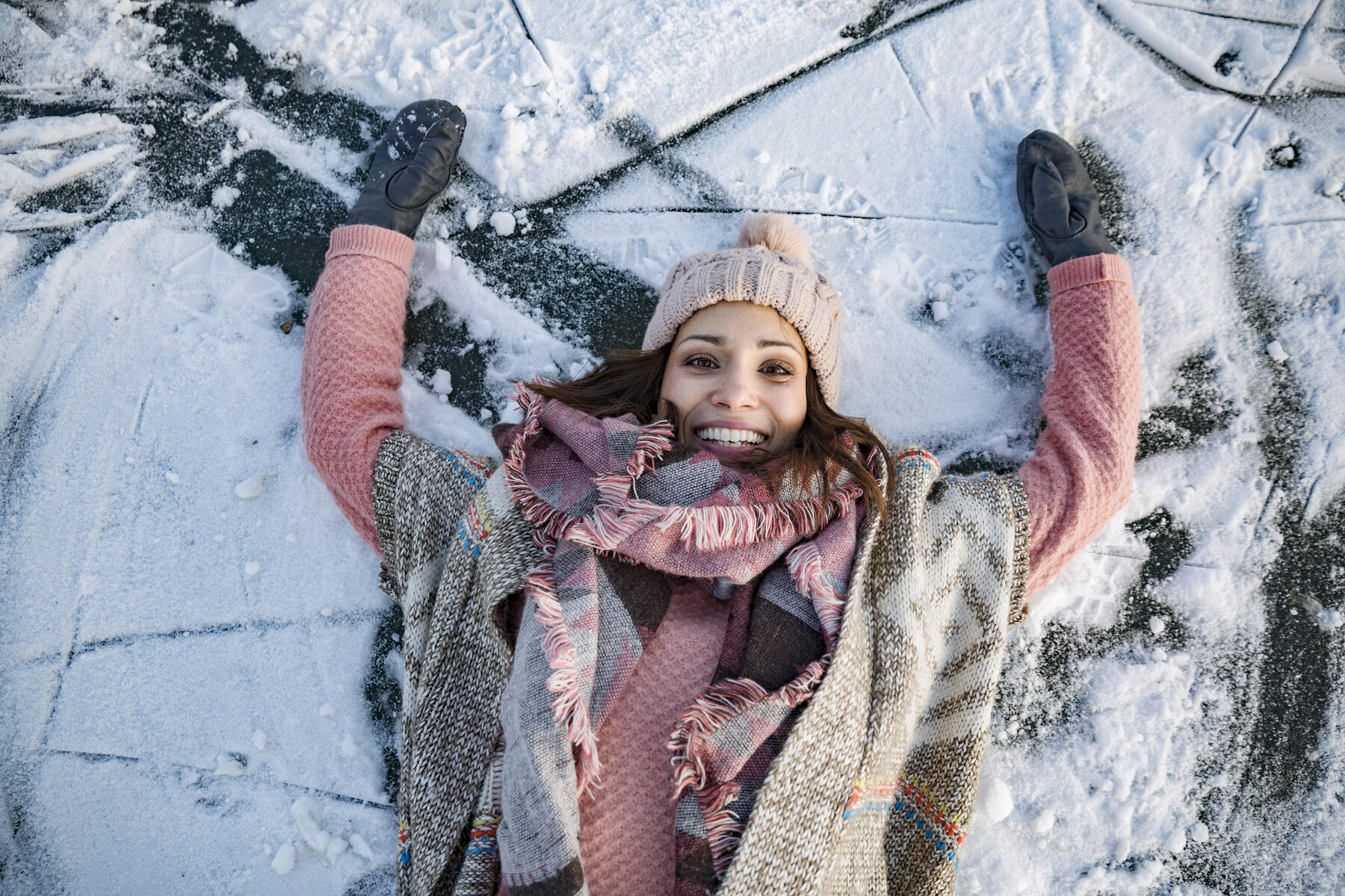 Stock Image, royalty-free, Portrait of happy woman lying down on frozen lake surface