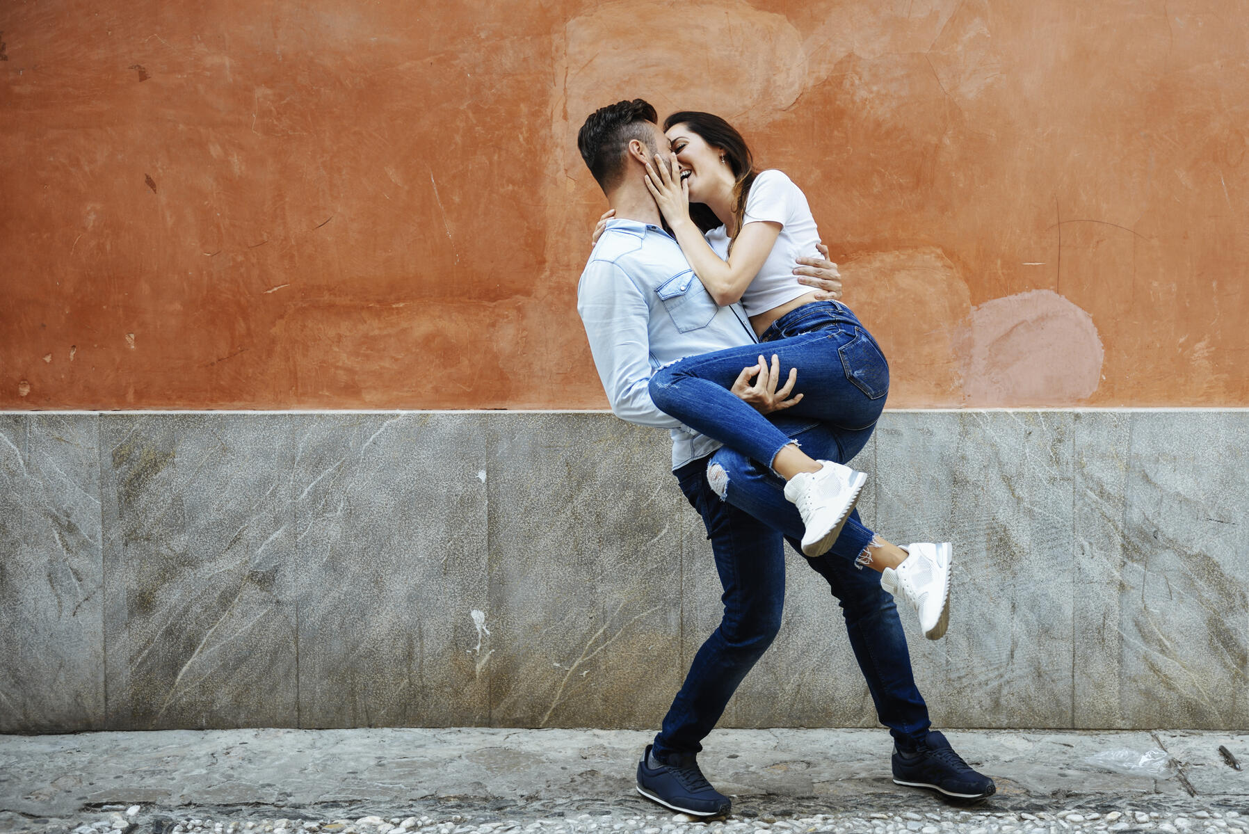 stock image, royalty-free, Carefree couple in love in front of a wall outdoors