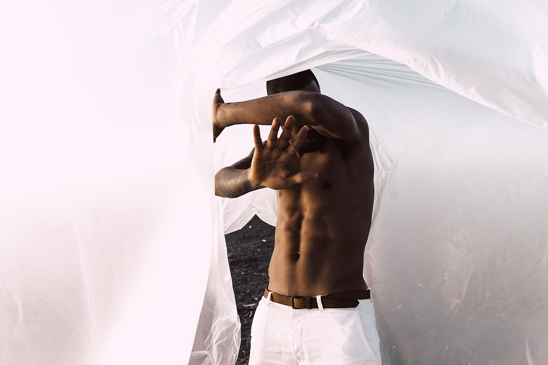 Bar-breasted young man in a plastic sheet covering his face, stock photo, royalty free, security, protection,