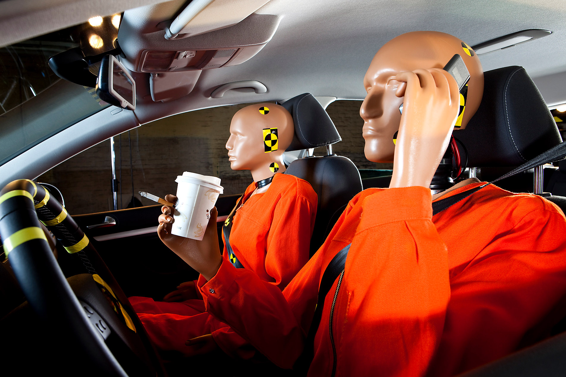 A crash test dummy carelessly using a cell phone while driving, with a crash test dummy as a passenger, safety, stock photo, Westend61, protection, security