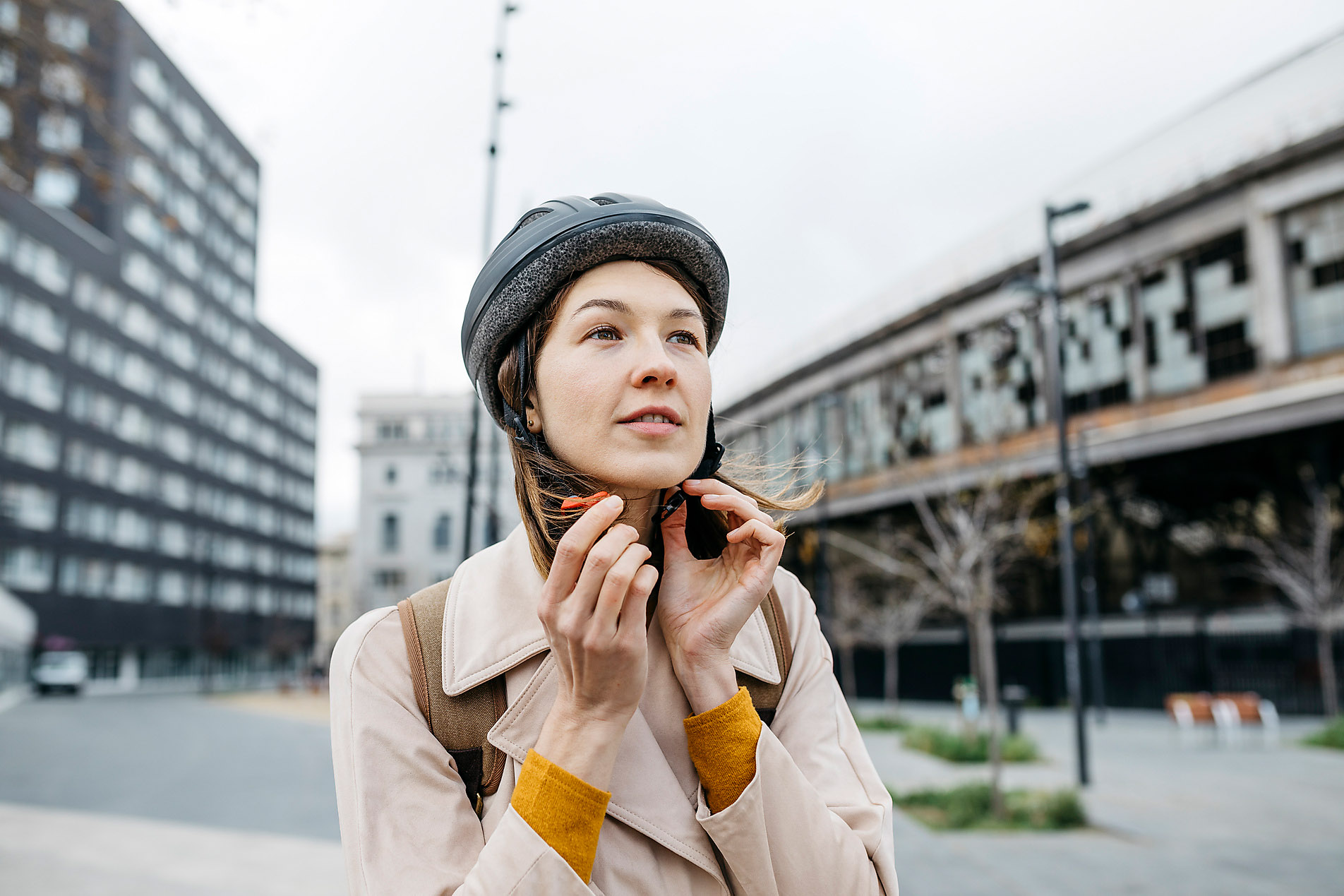 Portrait of a woman putting on a bicycle helmet in the city, safety, security, mobility, stock photo, royalty free,