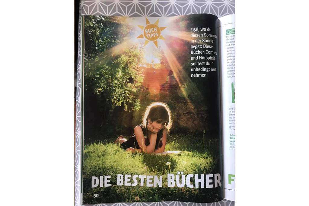 LVF003497 - Girl lying on a meadow reading a book