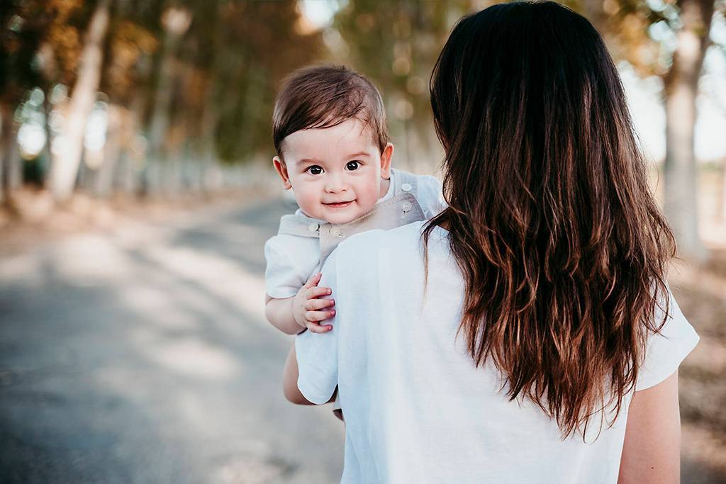 Mother carrying baby boy while standing on road outdoors
Royalty free image