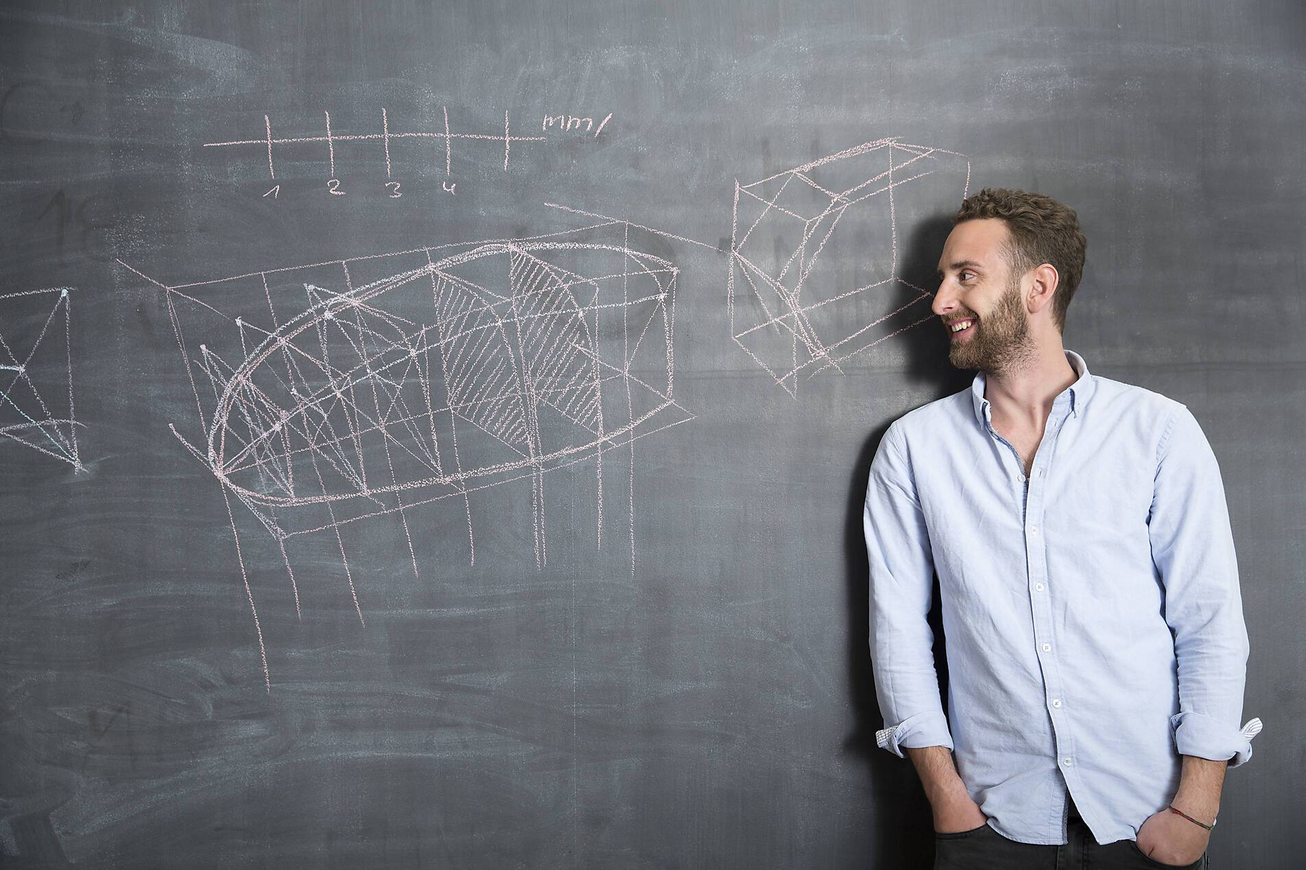 Stock image, royalty-free, Young man looking at drawing at blackboard
