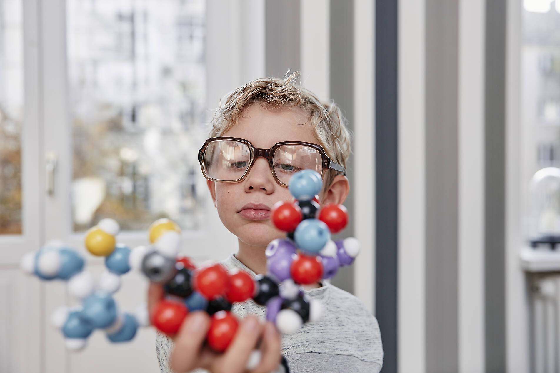 stock image, royalty-free, Boy wearing oversized glasses looking at molecular model