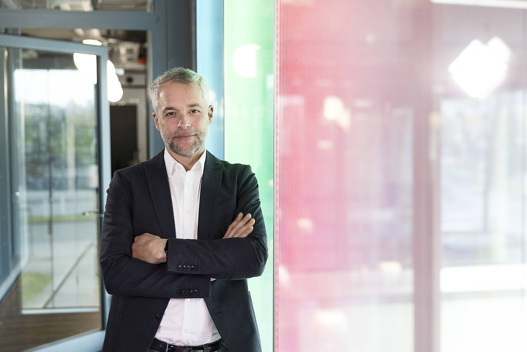 Confident male professional in businesswear standing by glass at office Royalty free image
