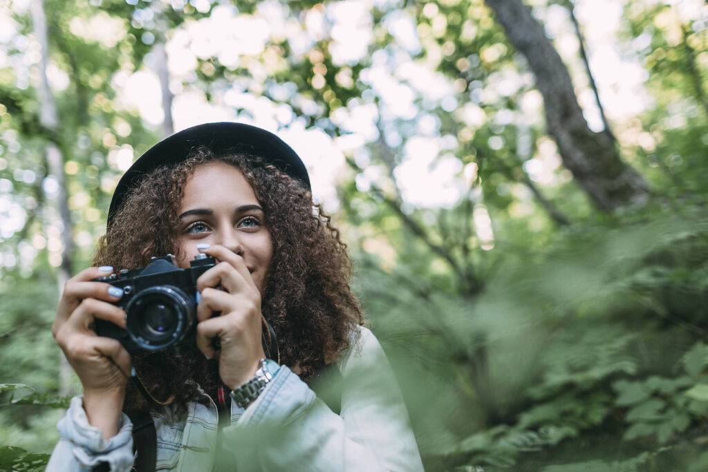 Portrait of smiling teenage girl taking pictures in nature, stock image, royalty-free,