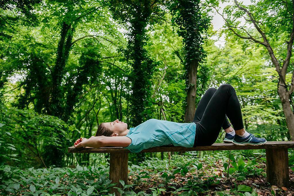 stock images, royalty-free, Young woman relaxing on bench in forest