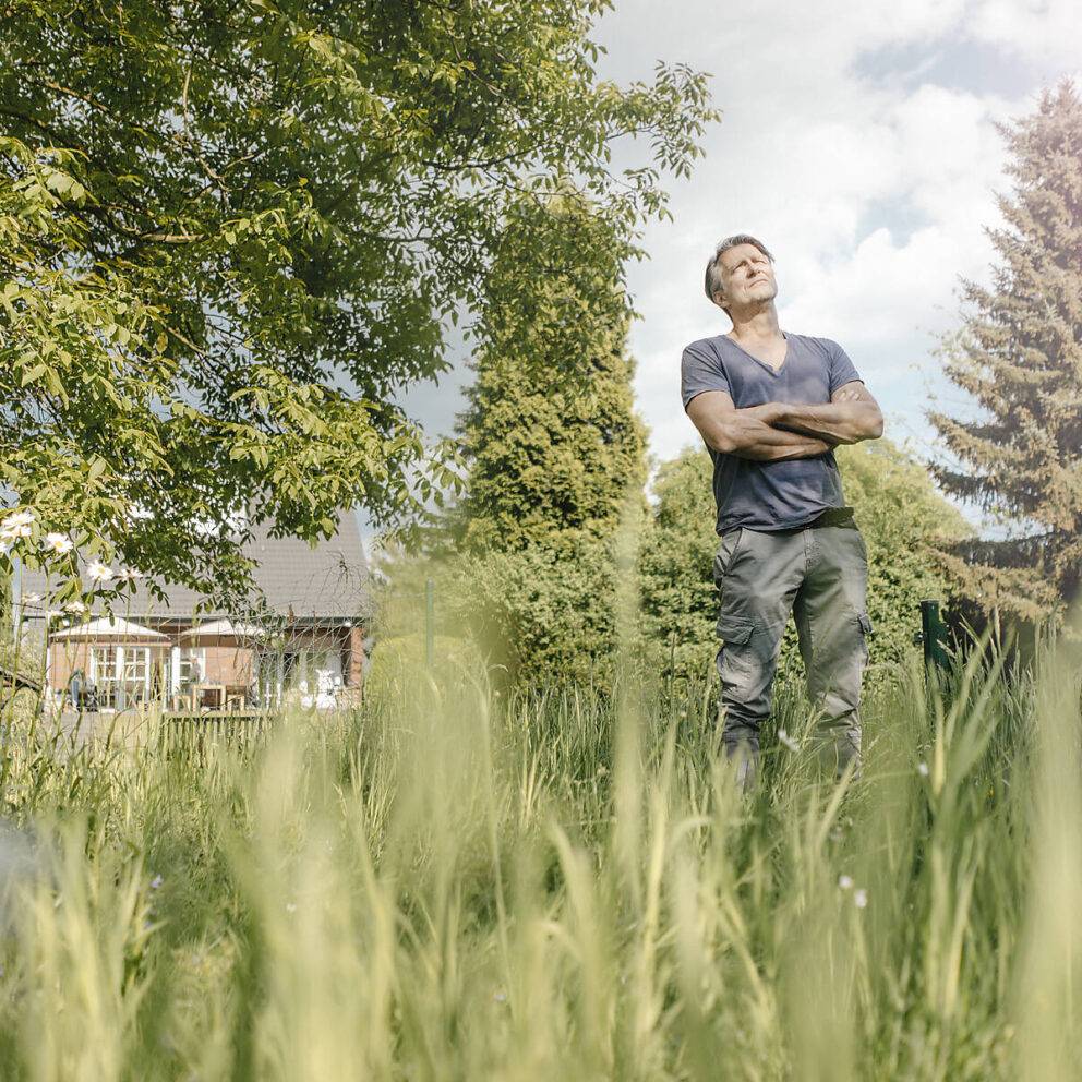 Stock image, royalty-free, Mature man standing in garden of his home