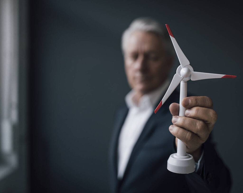 stock image, royalty-free, Senior businessman holding wind turbine model