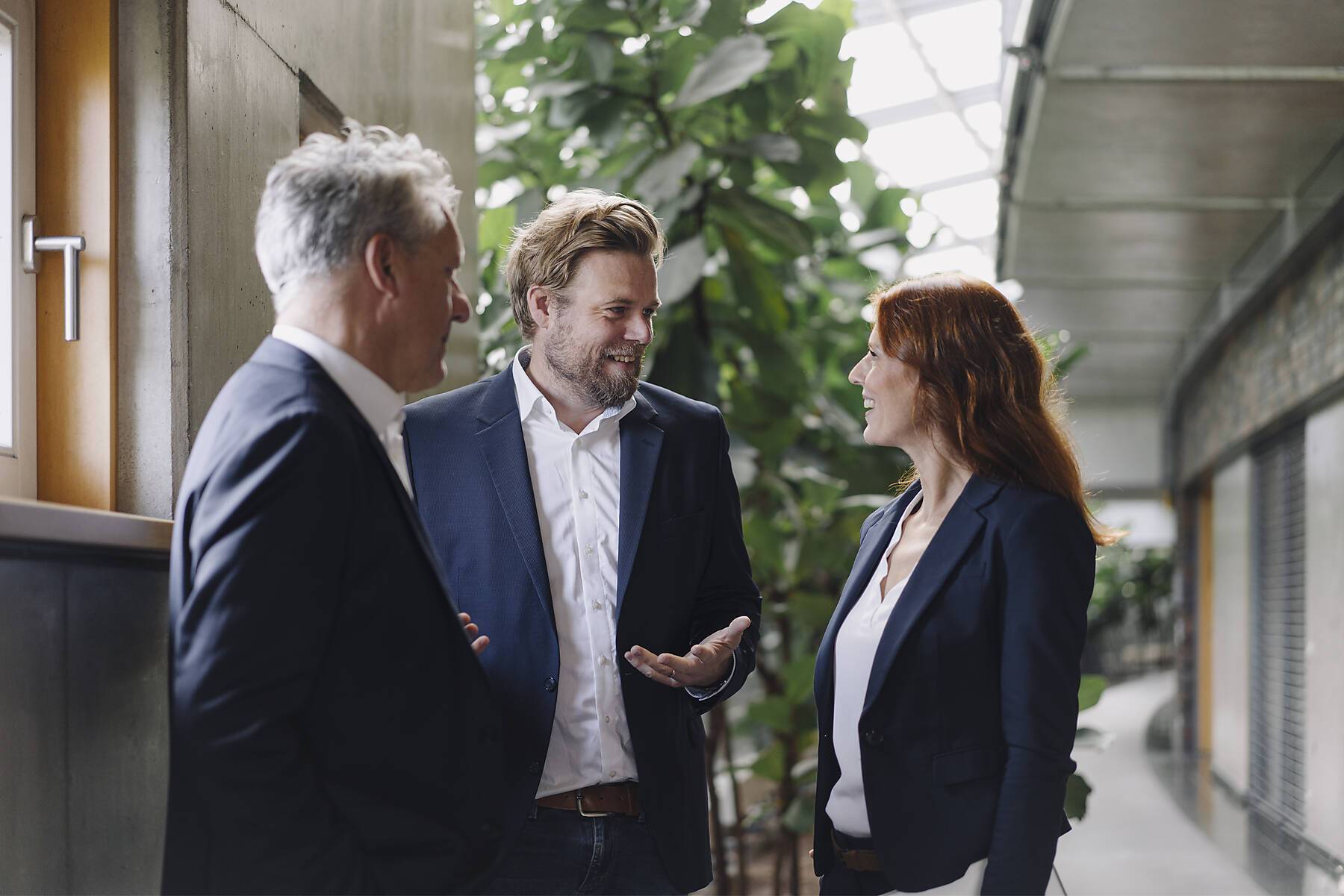 Smiling business people talking in modern office building