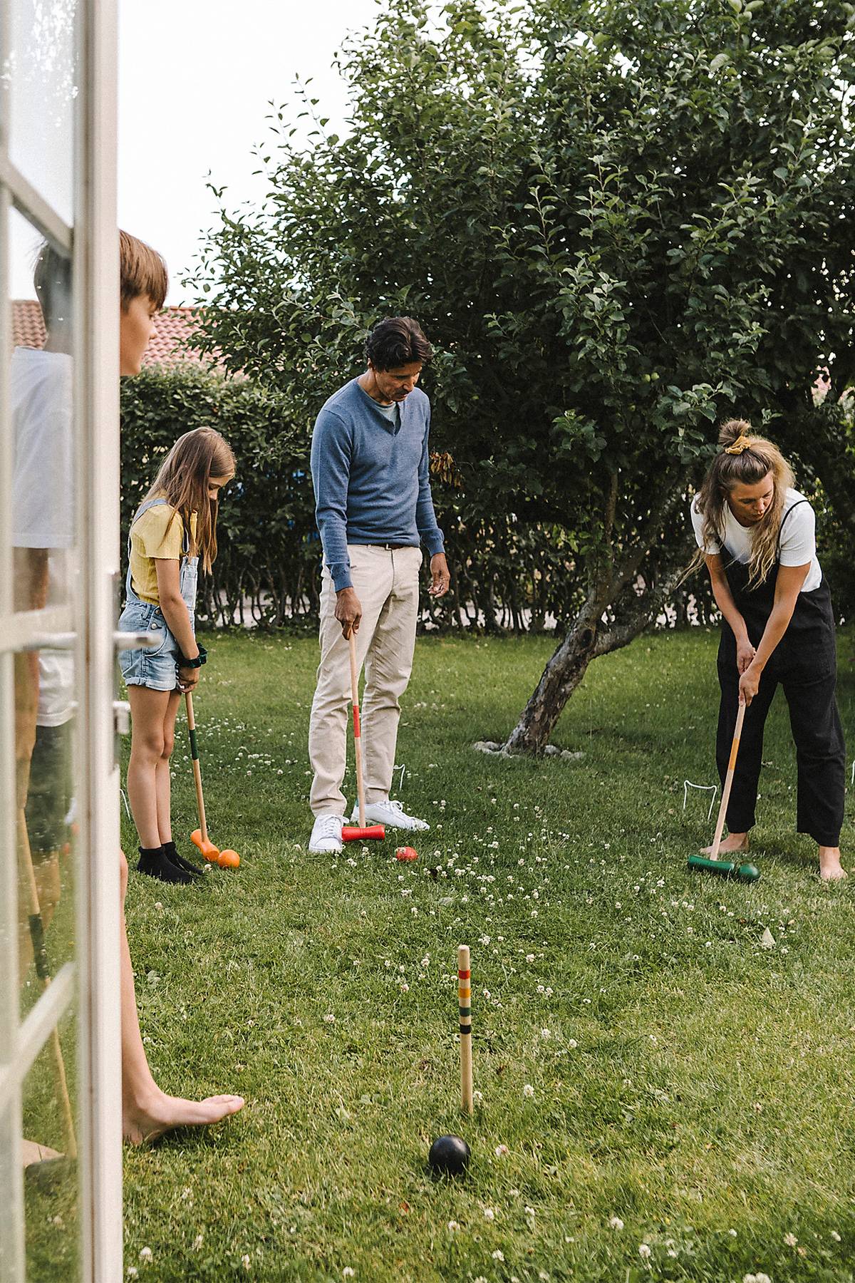 stock image, royalty-free, Parents playing polo with children in back yard
