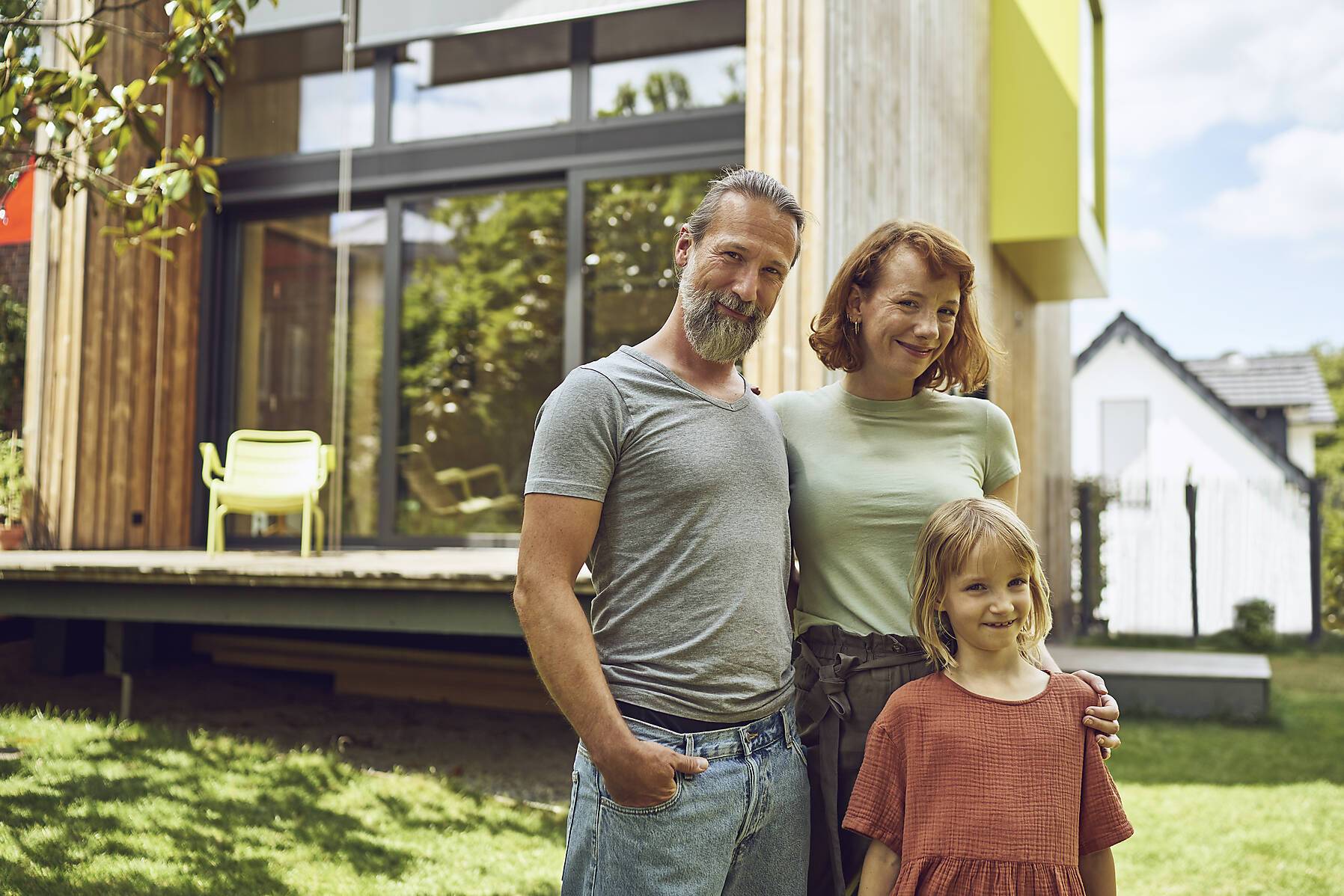 stock image, royalty-free, Smiling family posing while standing against tiny house in yard