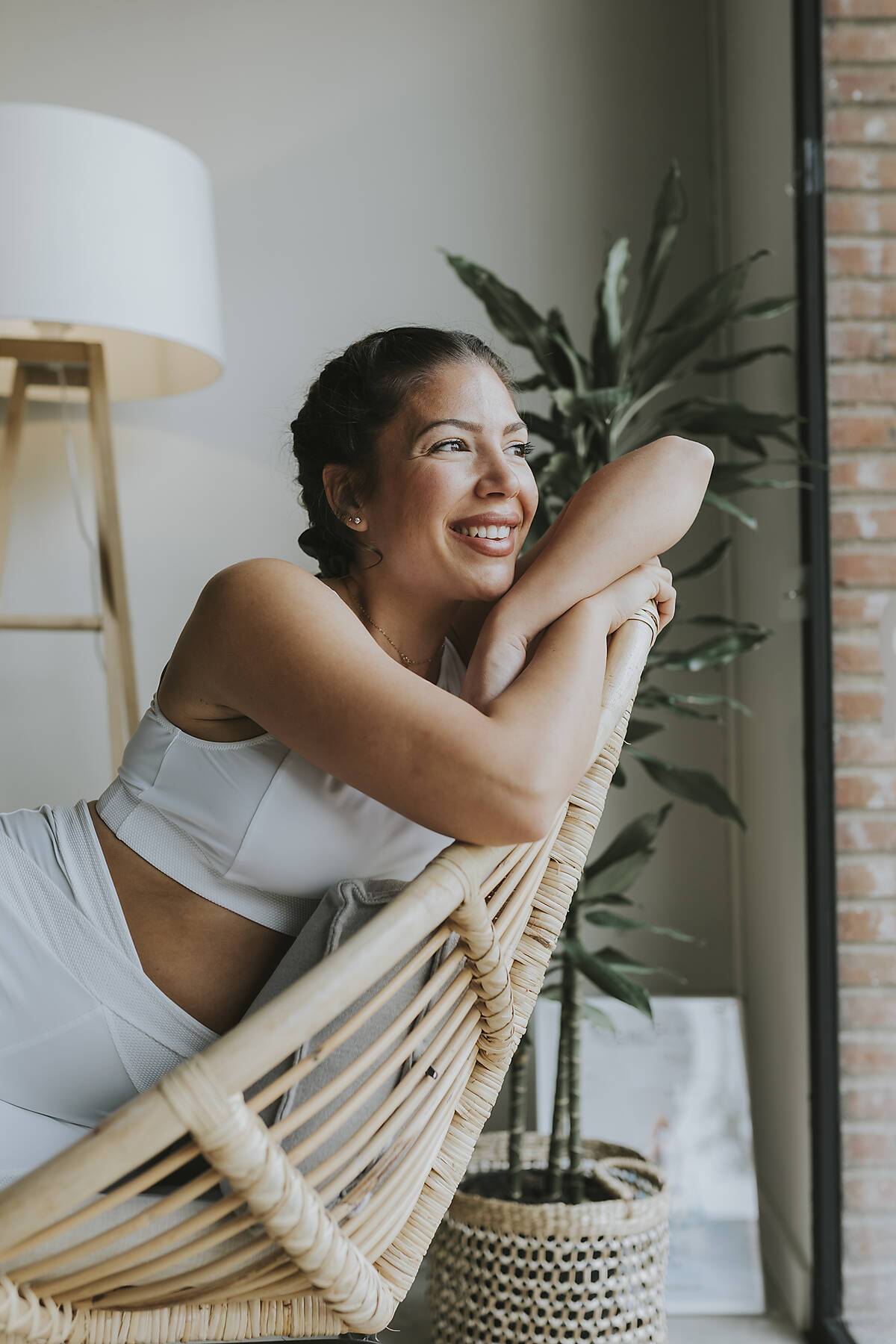 Smiling woman looking away while sitting on chair at health club